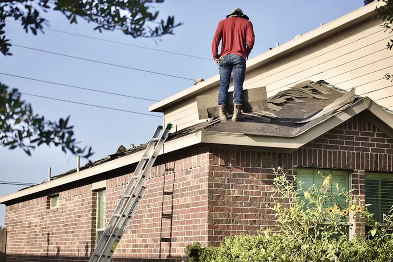 Professional roofer working on a residential roof in Poplar Ridge